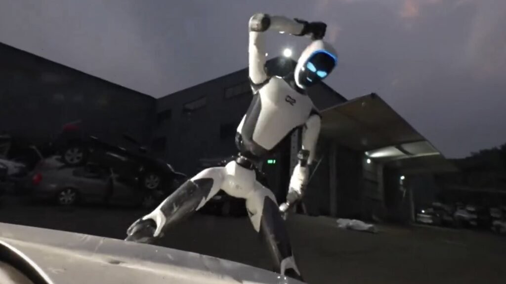 Unitree H2-X insansı robotu bir otomobilin kaputu önünde kung fu duruşunda